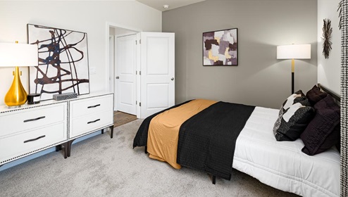 Carpeted bedroom with small window. New Home in Charlotte, North Carolina