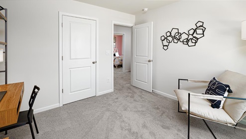 Carpeted bedroom being used as an office with small window. New Home in Charlotte, North Carolina