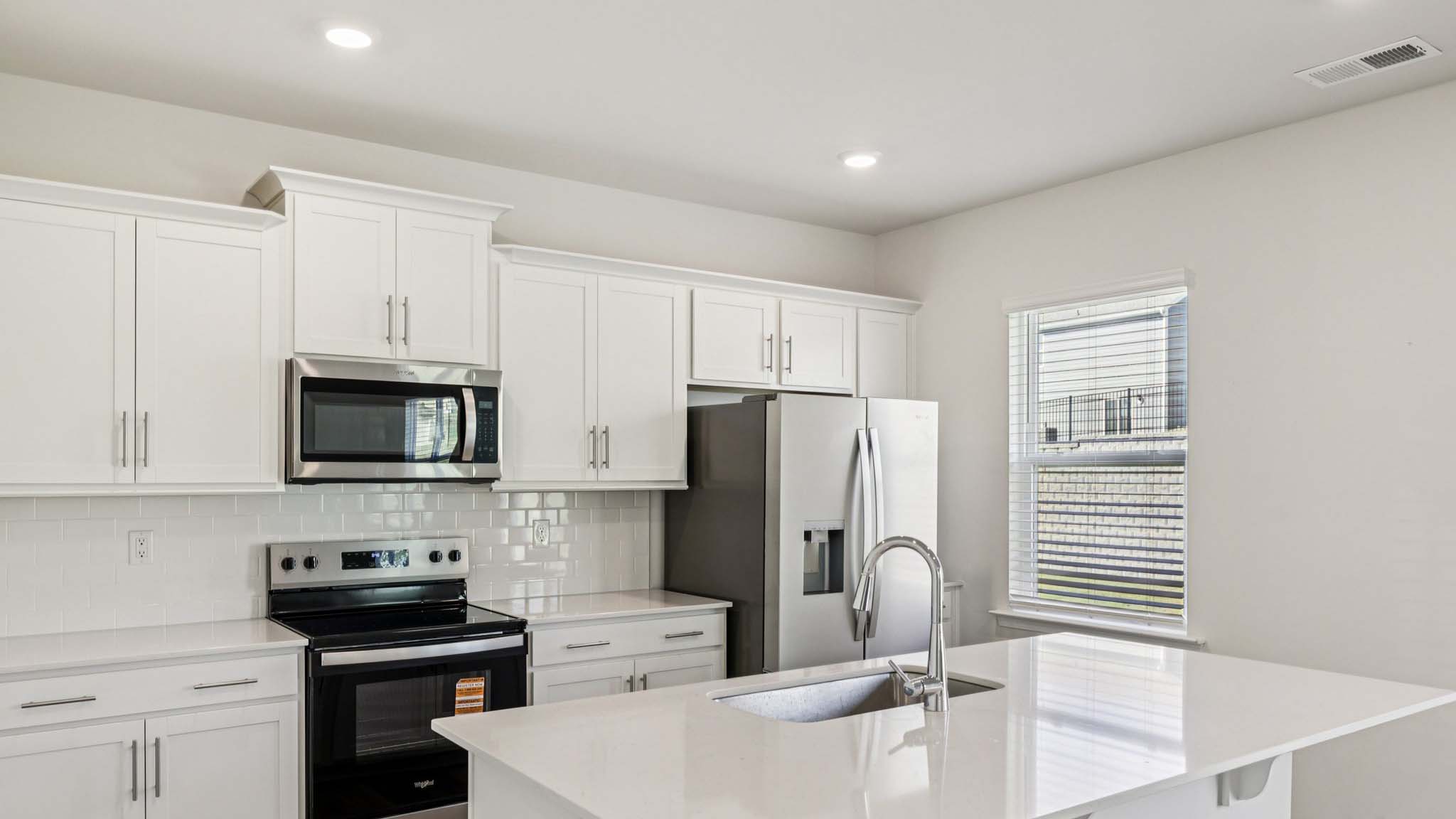 Kitchen with island, white cabinets and wood floors