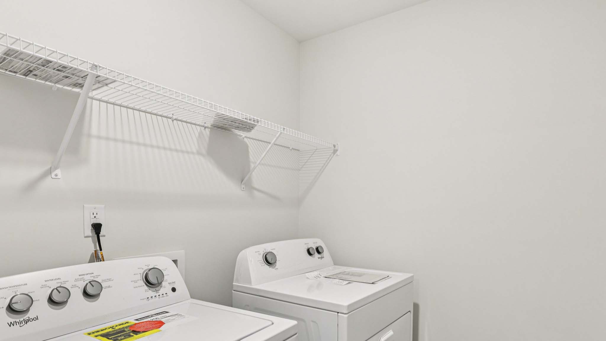 Laundry Room with racks above machines