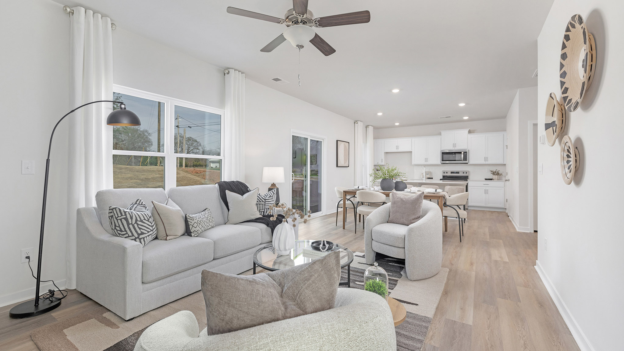 Open greatroom  beside kitchen, against staircase, with large window