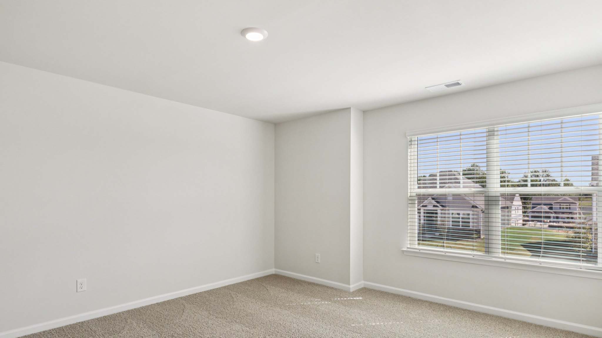 carpeted bedroom with large window