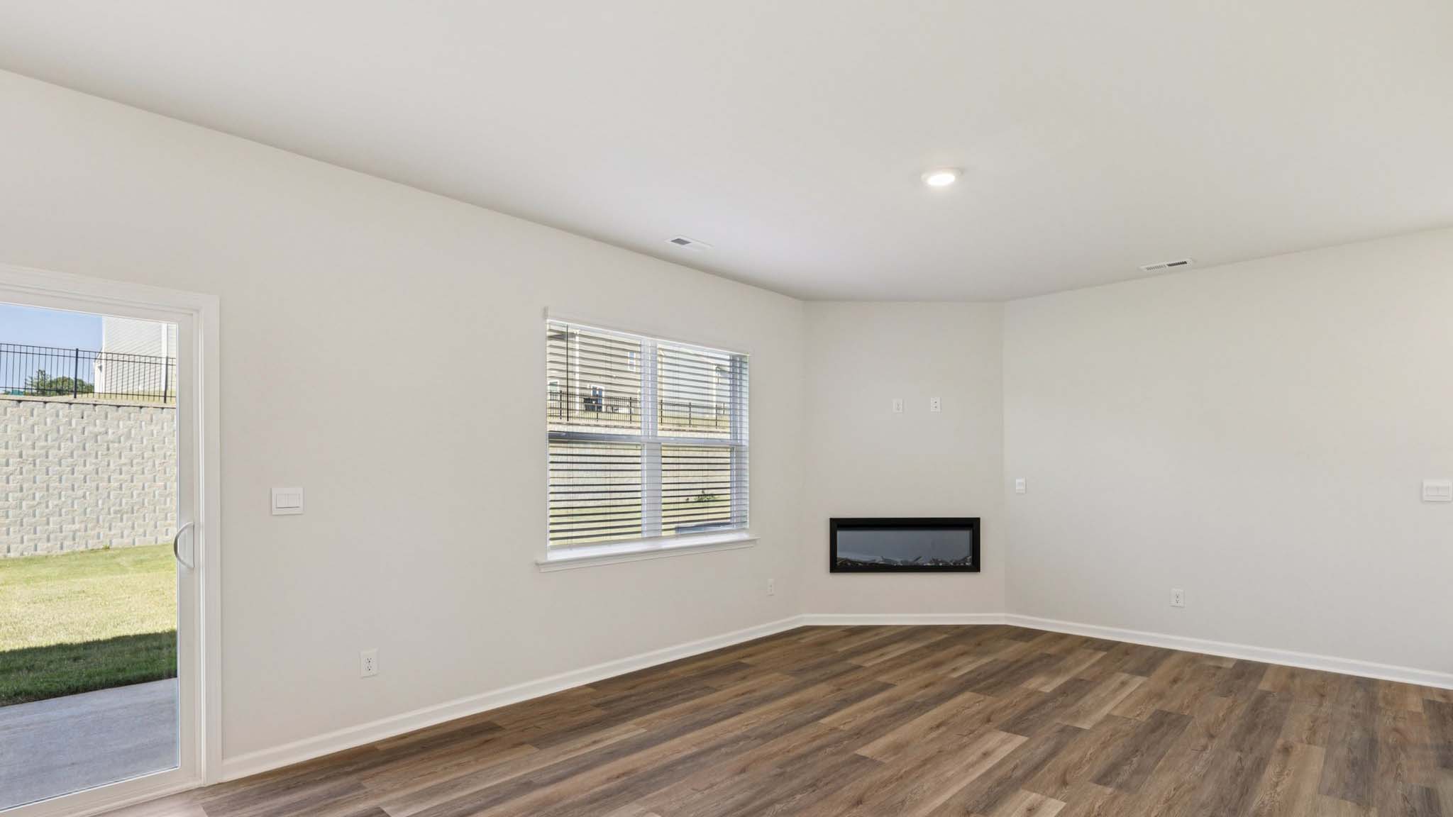 Open greatroom  beside kitchen, against staircase, with large window