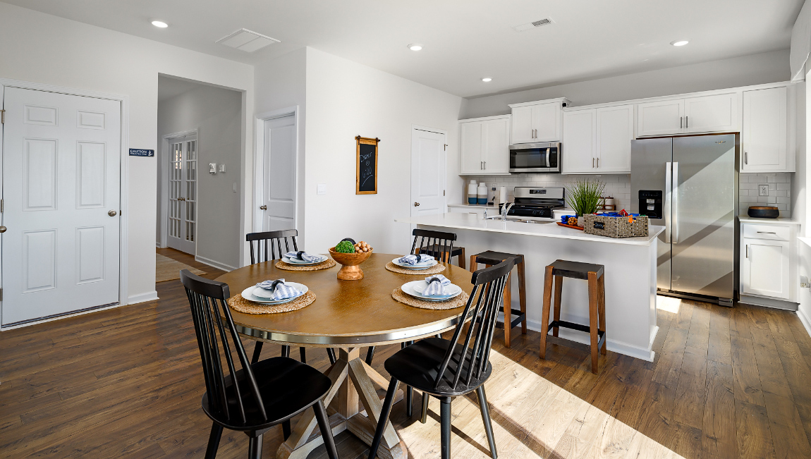 Kitchen with island, white cabinets and wood floors