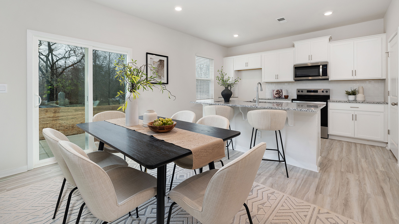 Open greatroom  beside kitchen, against staircase, with large window