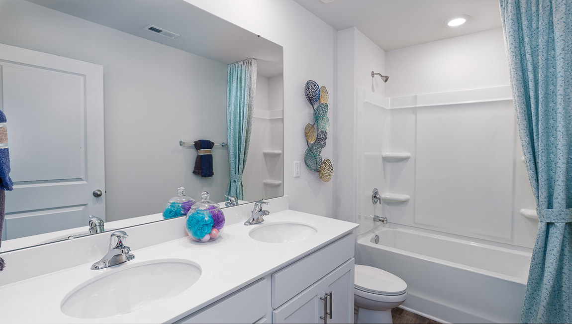 Bathroom with double sinks and bathtub