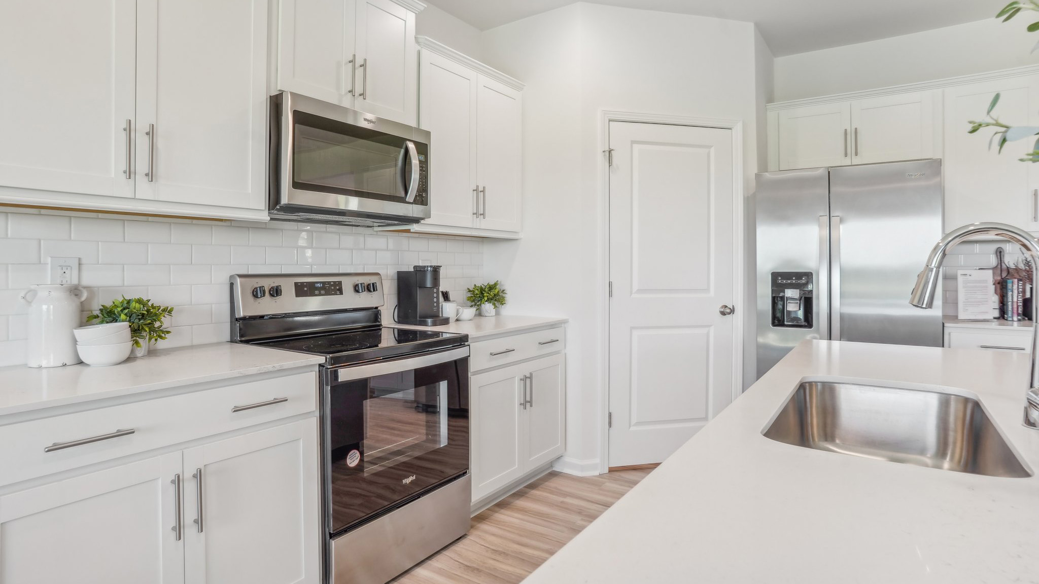 kitchen and island with white cabinets and stainless steel appliances