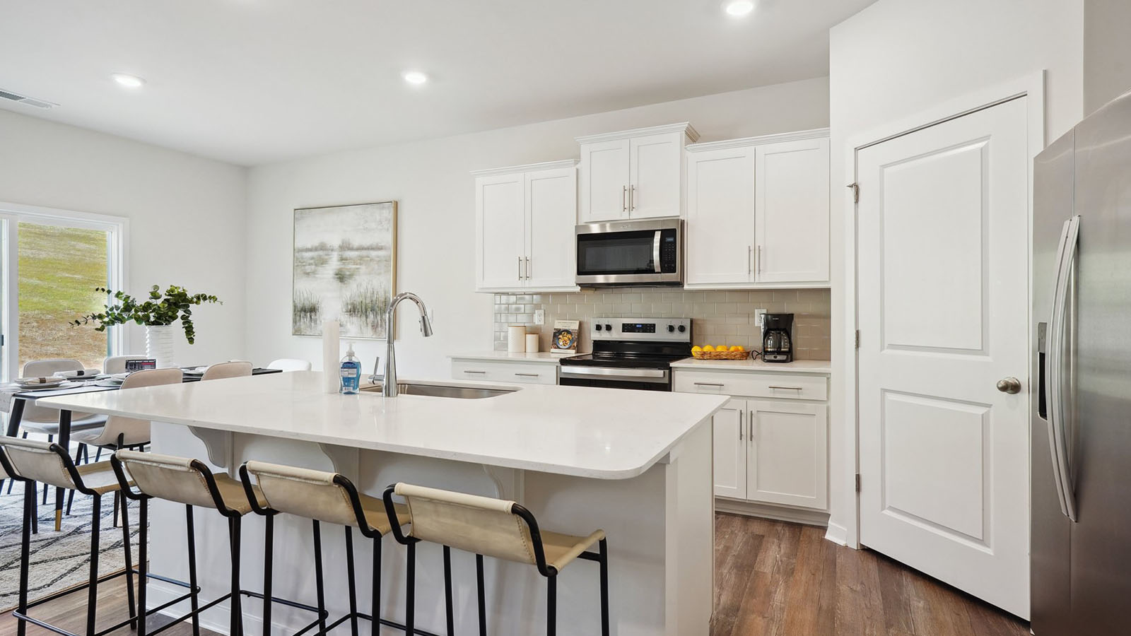 kitchen and island with white cabinets and stainless steel appliances