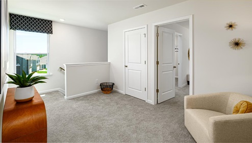 Upstairs carpeted loft with small window