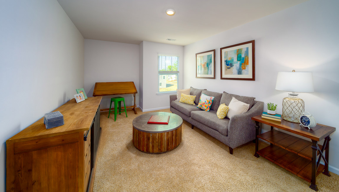 Open upstairs carpeted loft space with small window