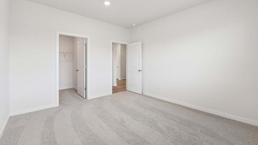 Carpeted bedroom with windows