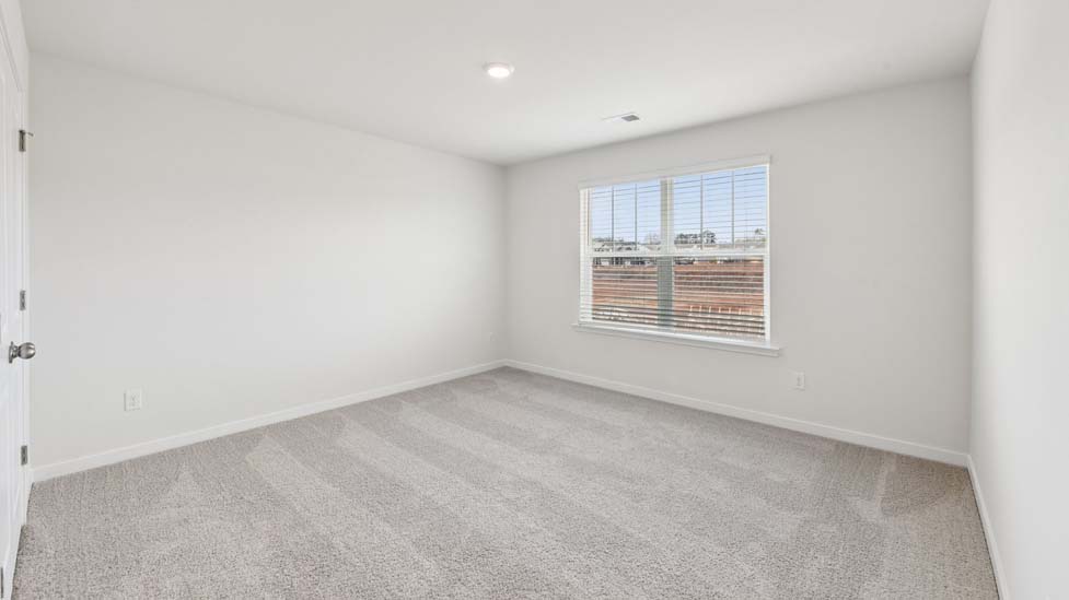 Carpeted bedroom with windows