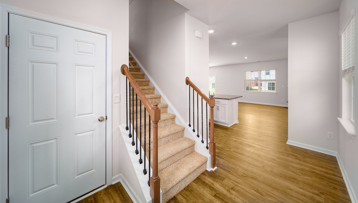 Welcoming foyer with view of front door and stairs