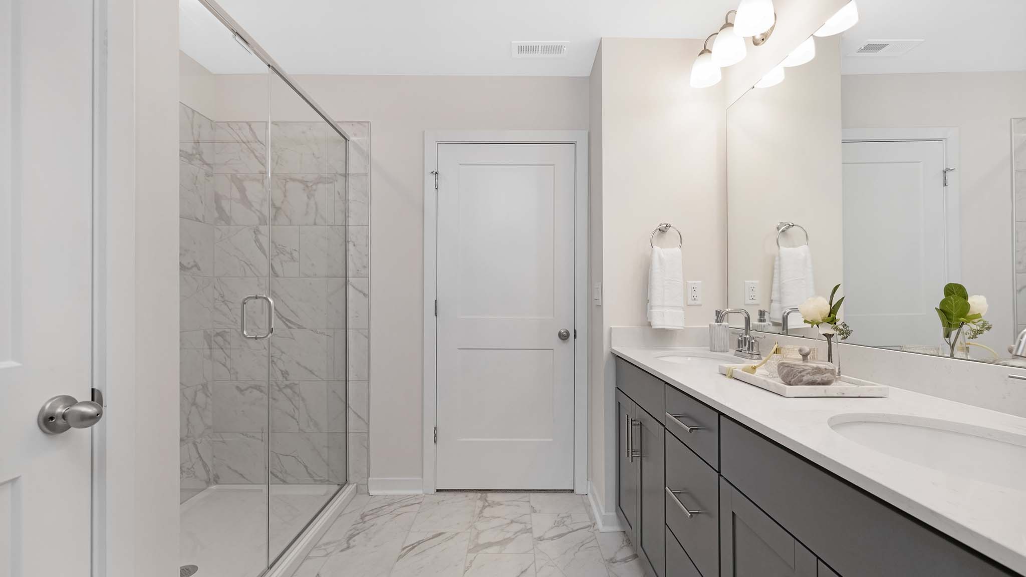 primary bathroom with dual sink vanity and walk in shower