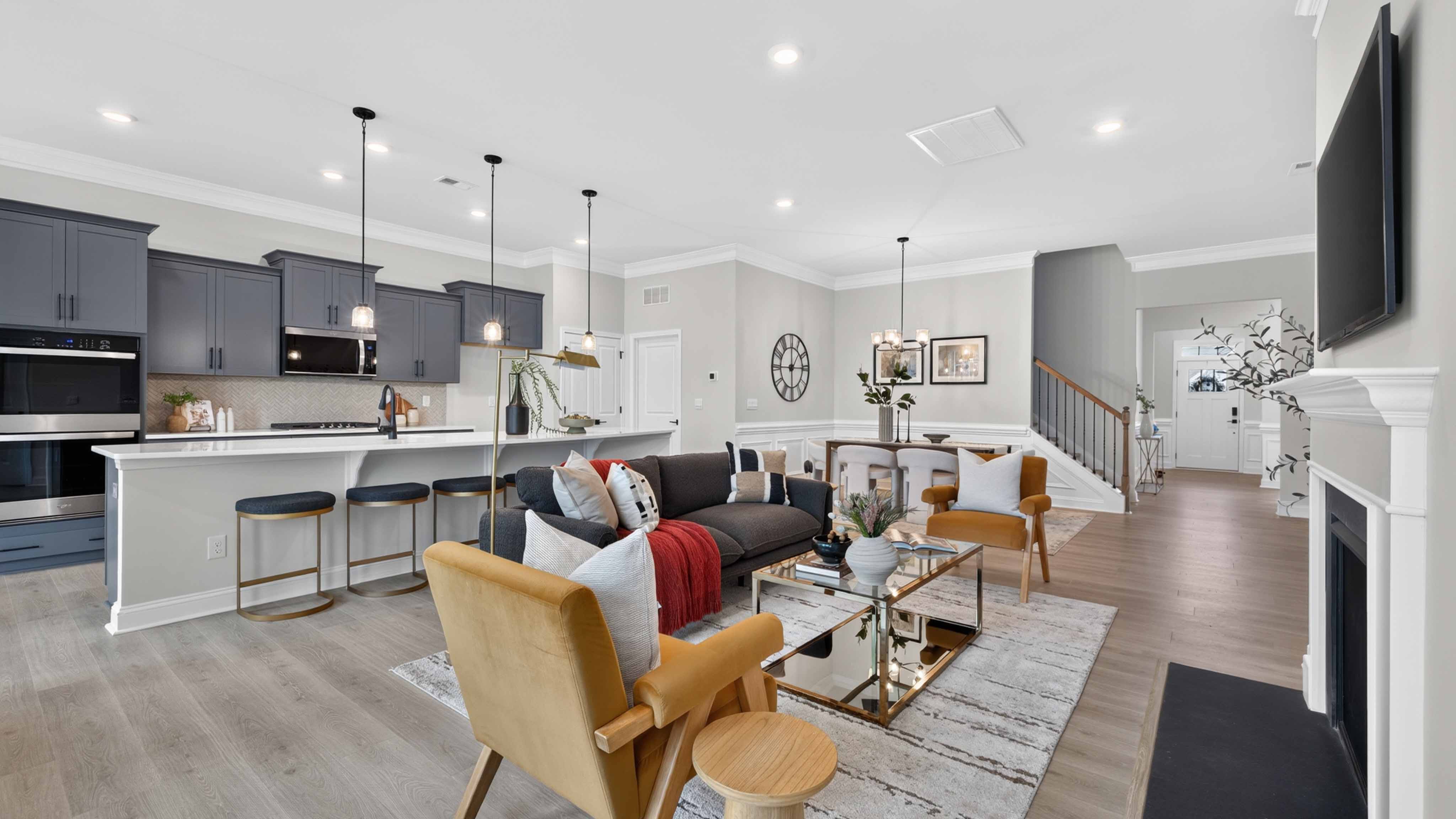 Open living room with wood floors, three windows, and fireplace