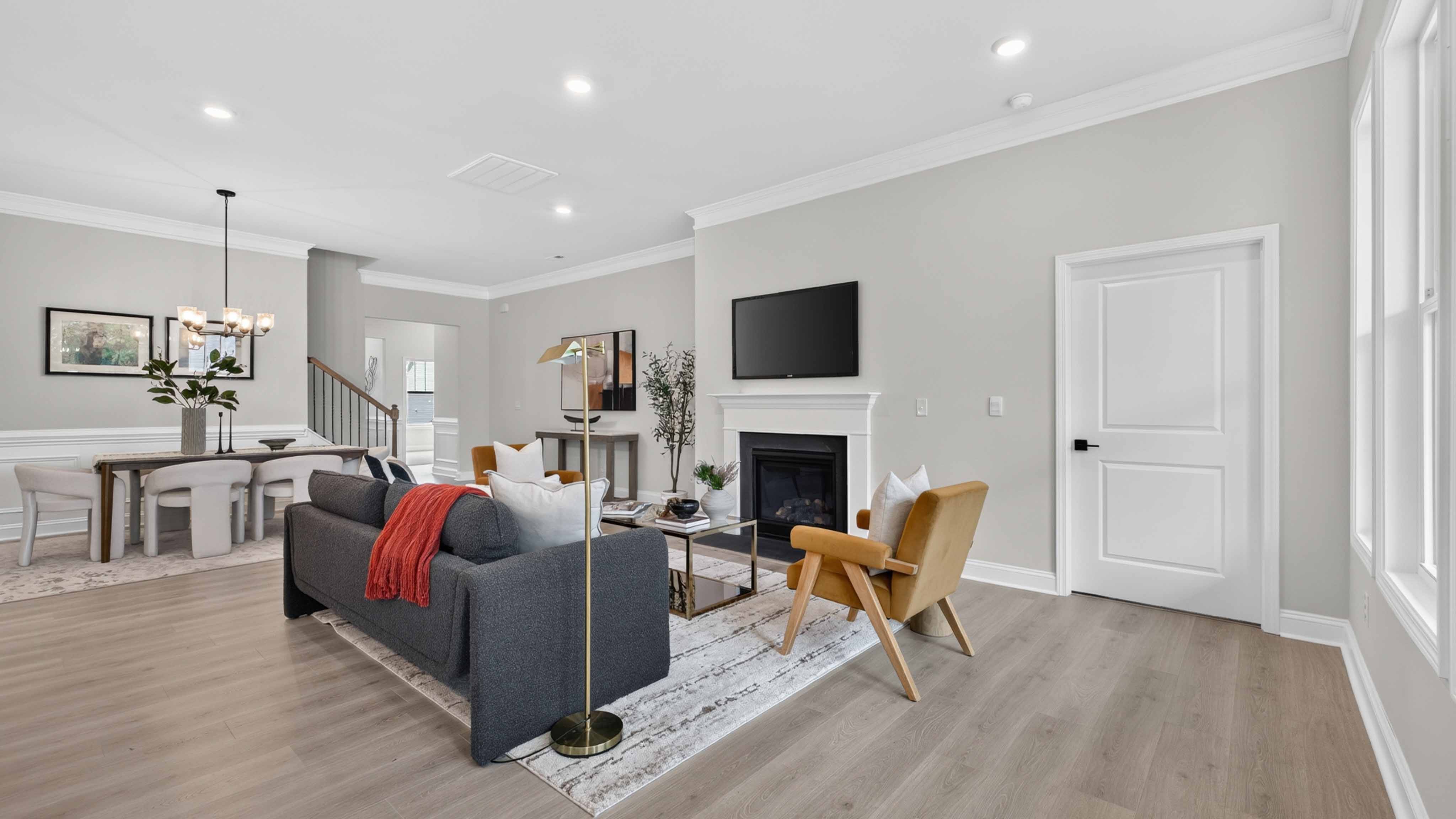 Open living room with wood floors, three windows, and fireplace