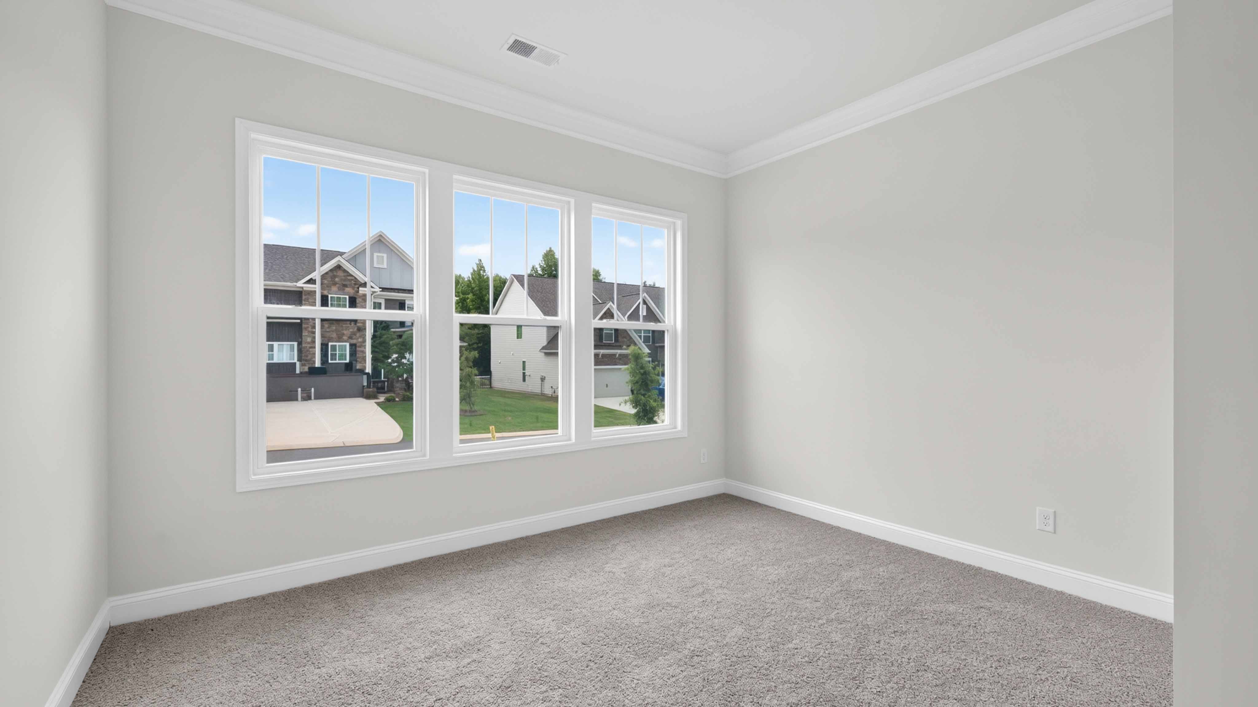 Carpeted bedroom three large windows