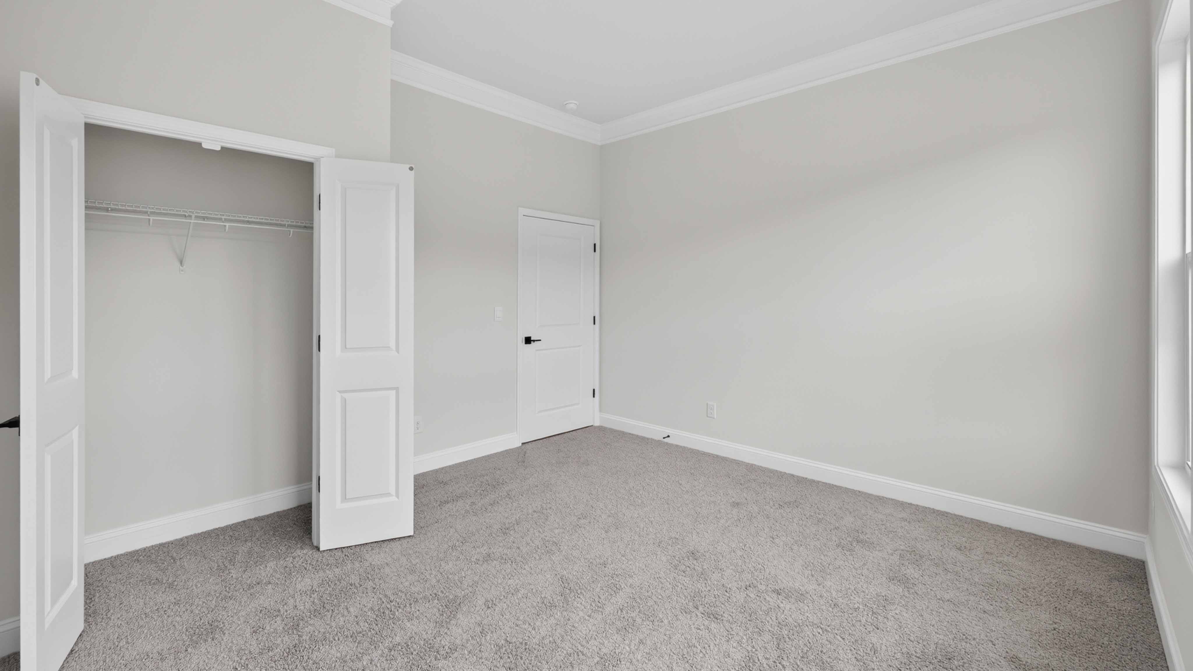Carpeted bedroom three large windows