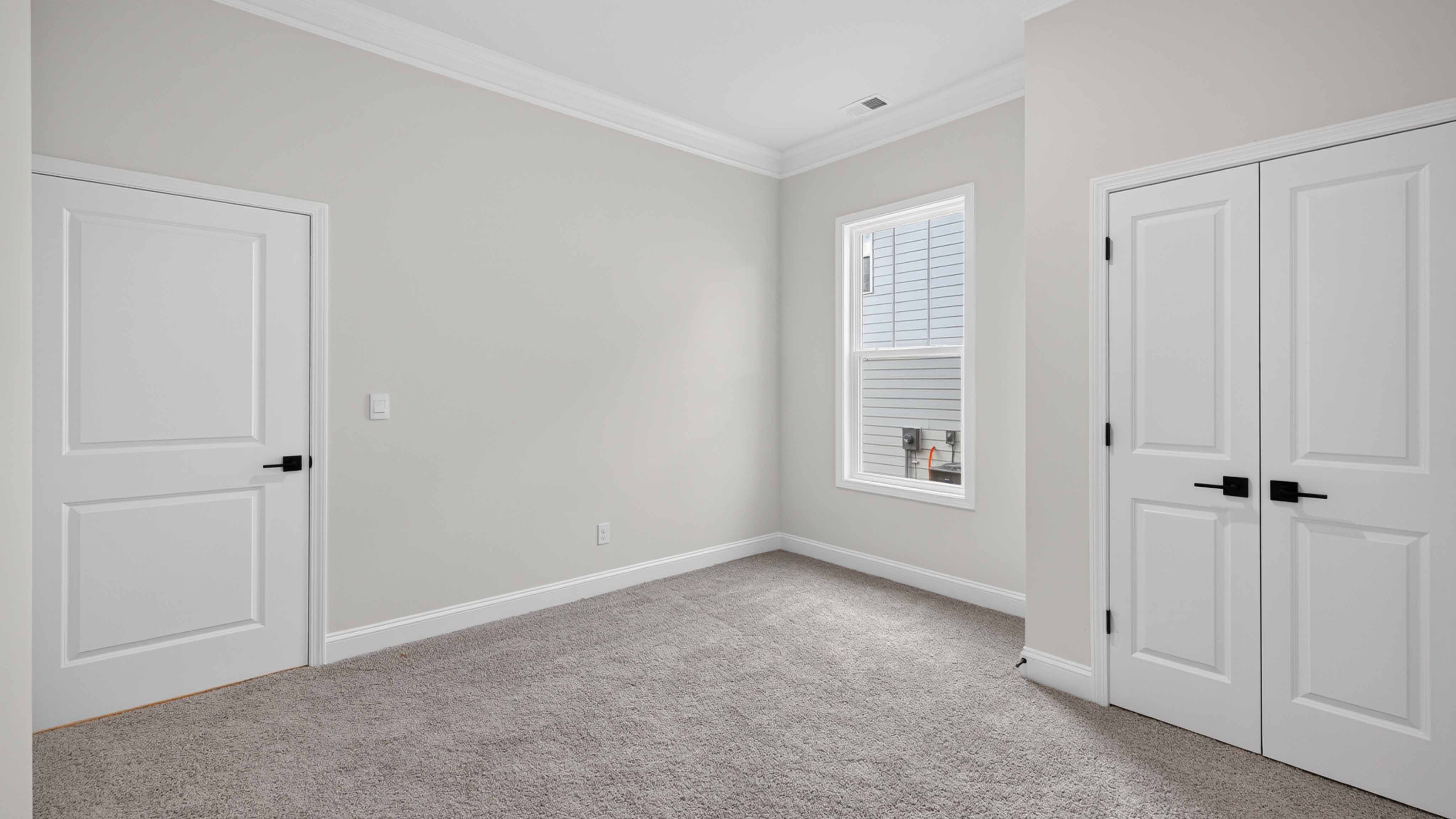 Carpeted bedroom three large windows