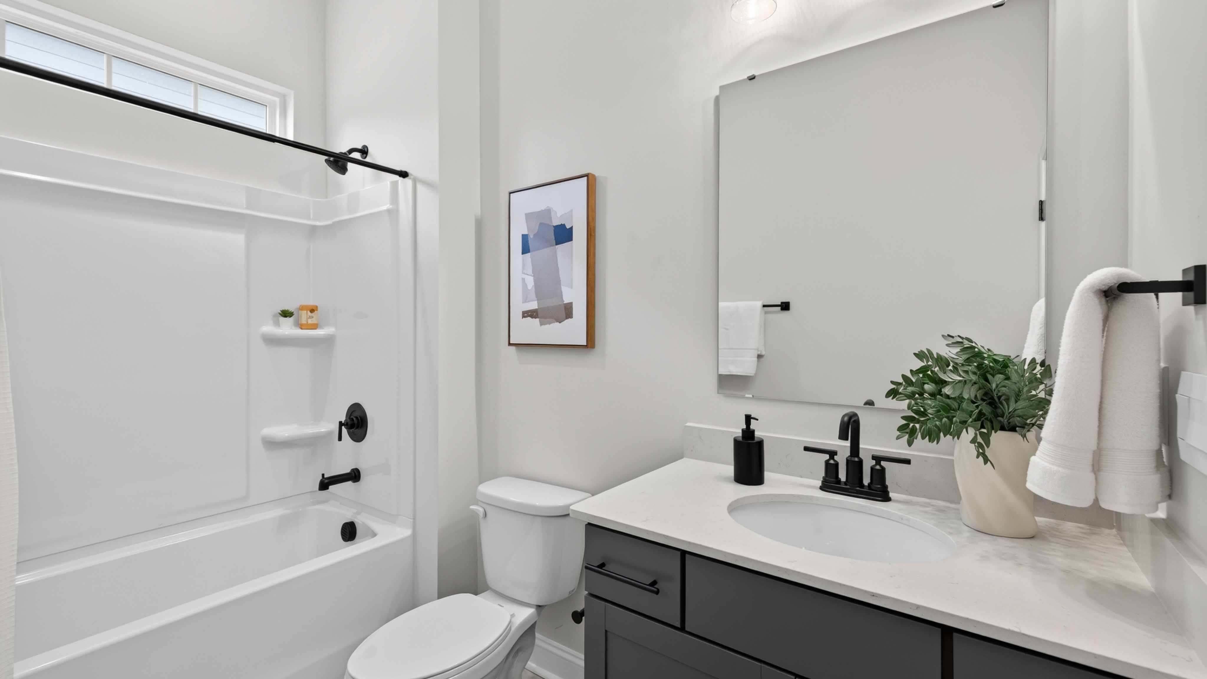 Bathroom with bathtub, white cabinets and counters