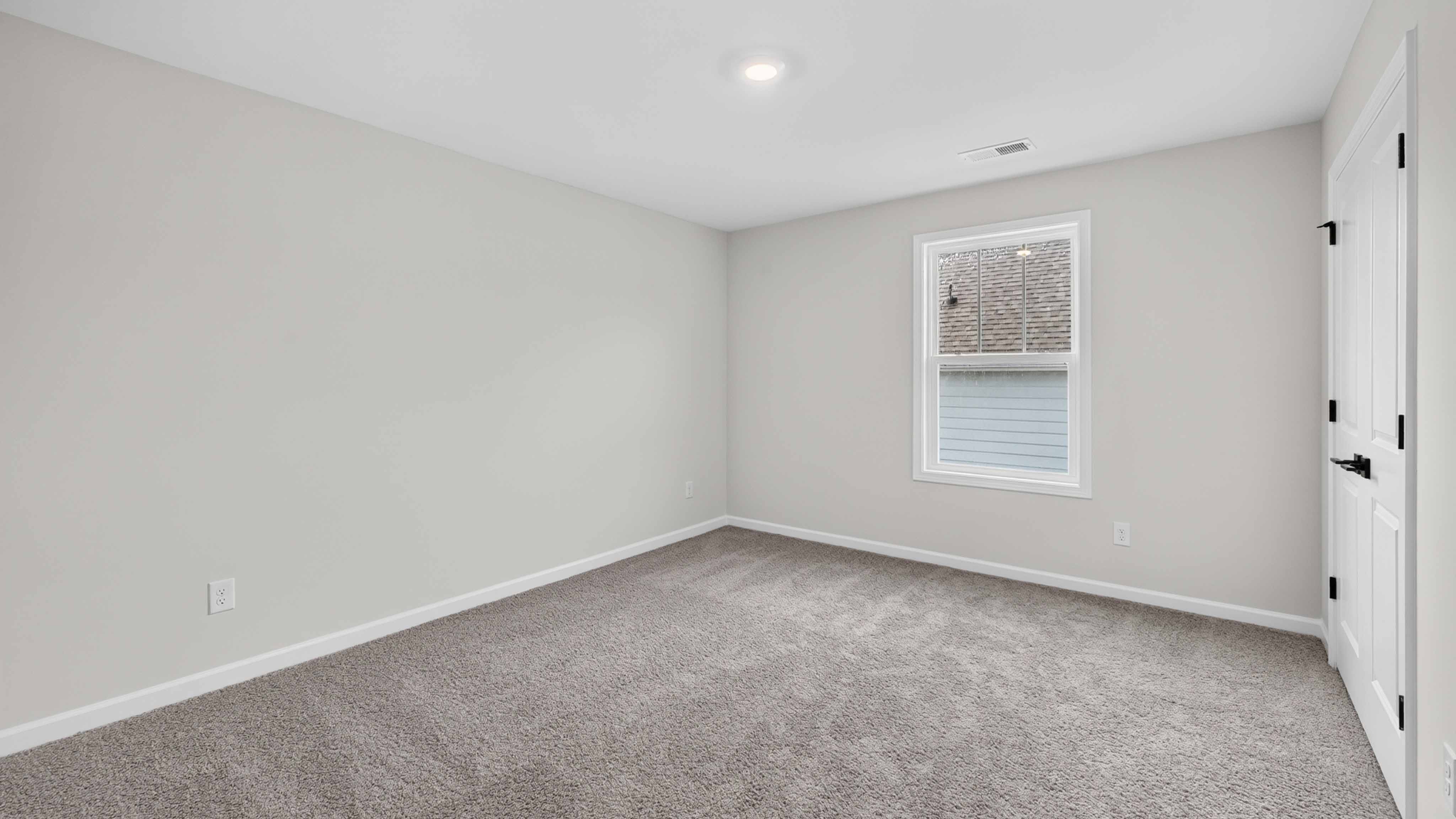 Carpeted bedroom three large windows