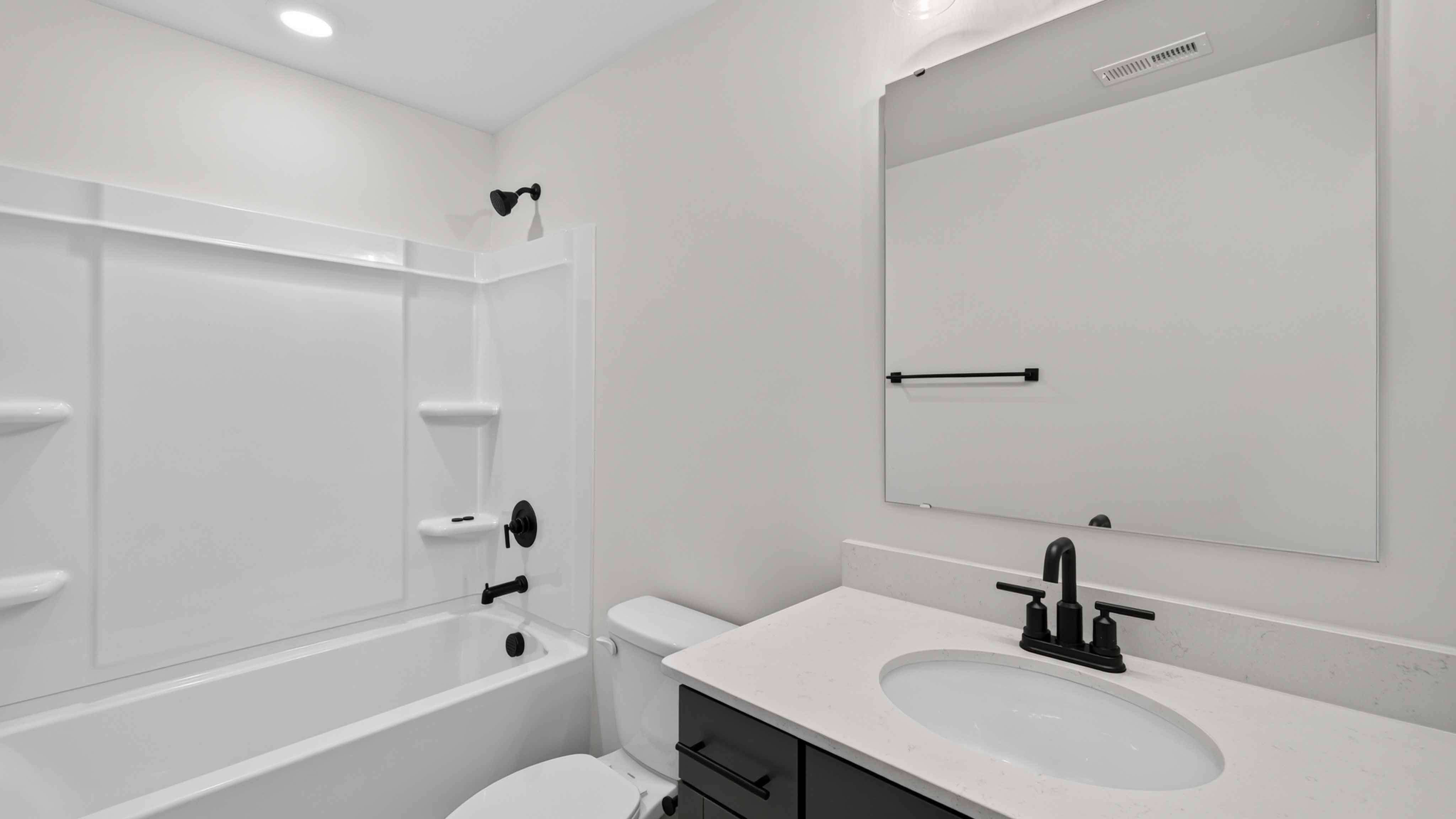 Bathroom with bathtub, white cabinets and counters