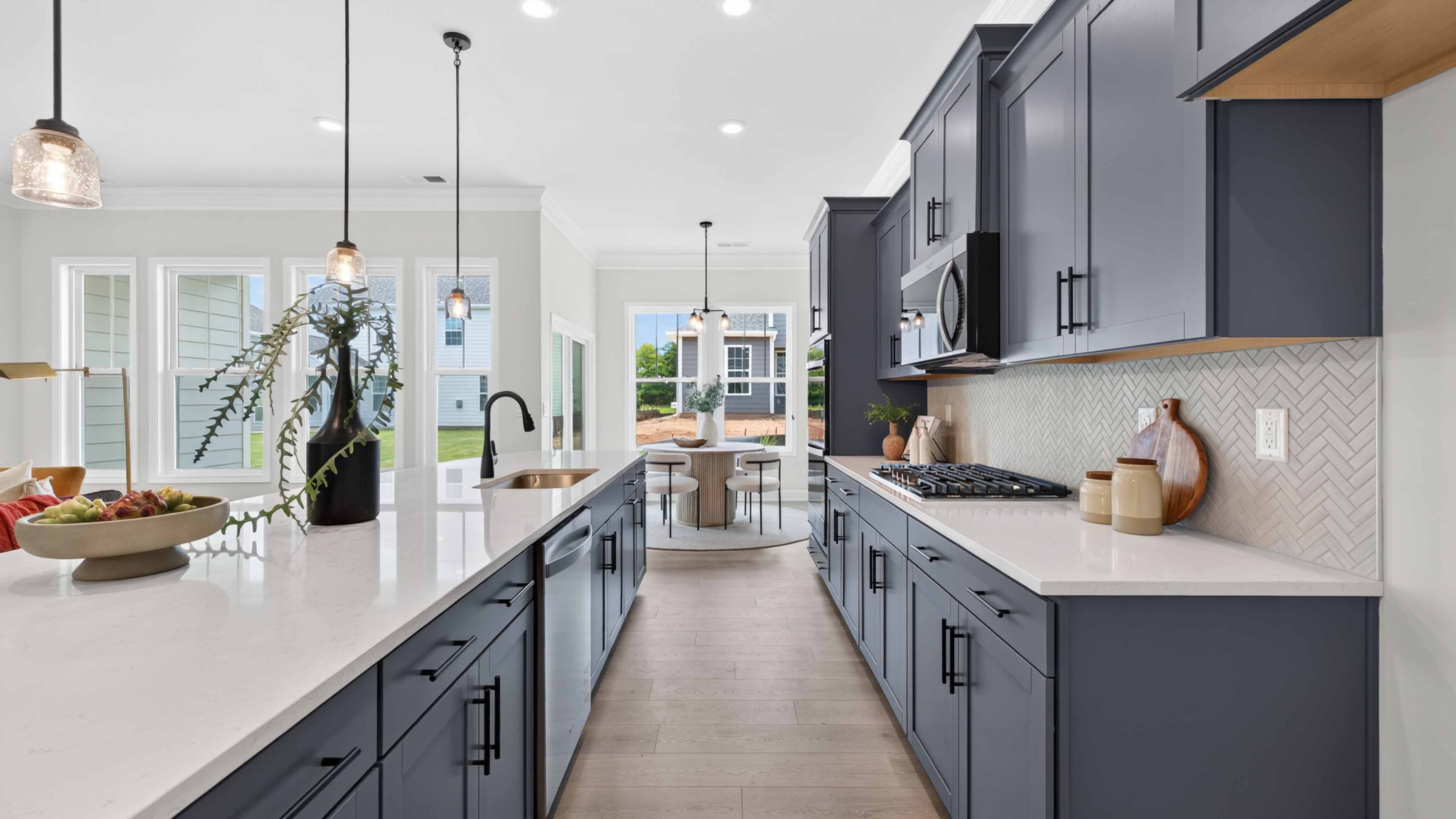 Kitchen and island with wood floors, white cabinets and counters, stainless steel appliances, and seating at island bar