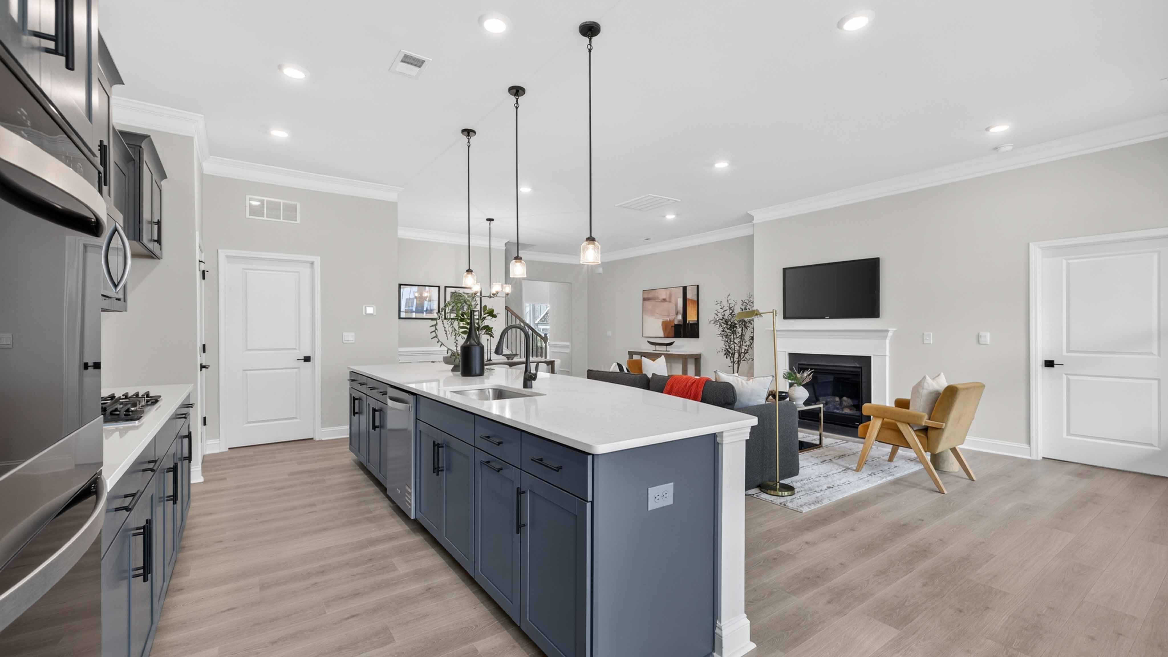 Kitchen and island with wood floors, white cabinets and counters, stainless steel appliances, and seating at island bar
