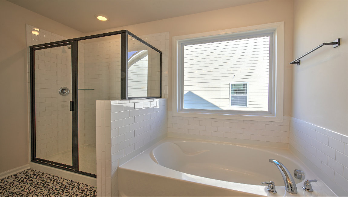 Bathroom with bathtub and glass door shower