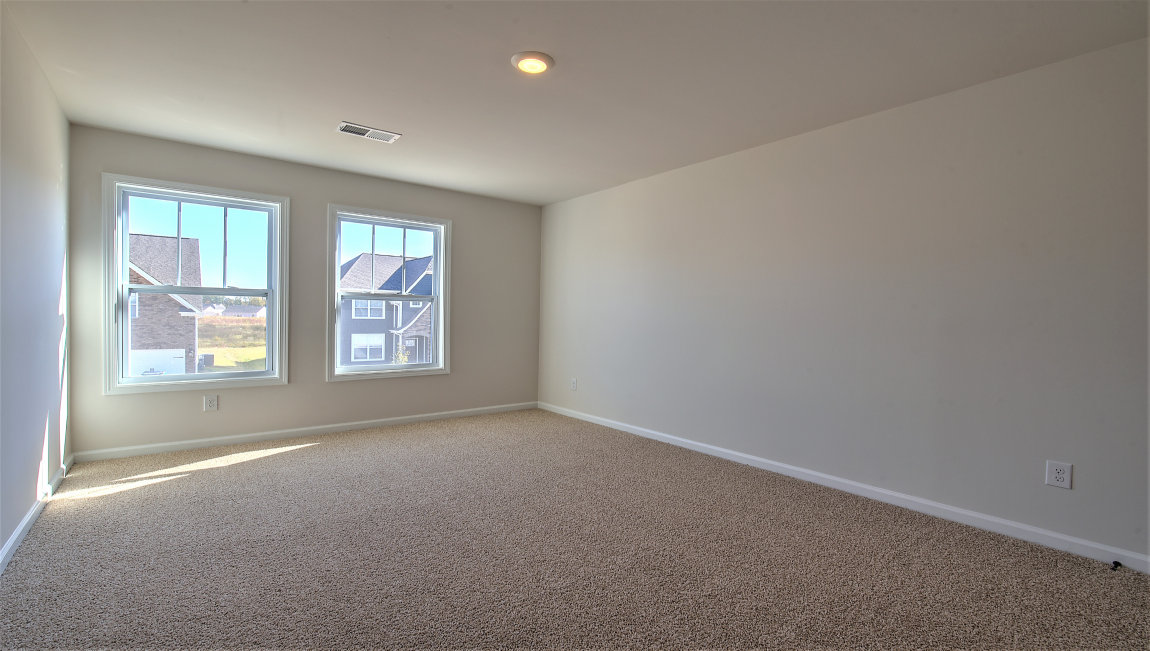 Carpeted bedroom with two large windows
