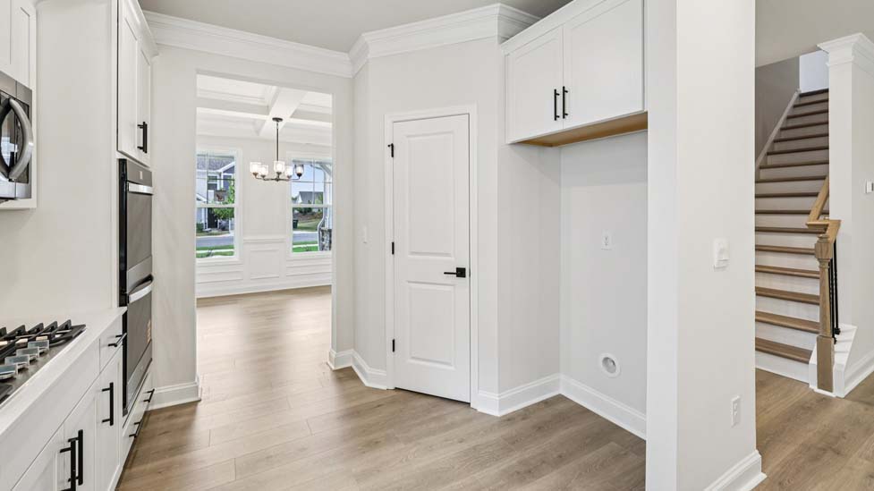 Kitchen and island with white cabinets, breakfast area at island bar, and stainless steel appliances