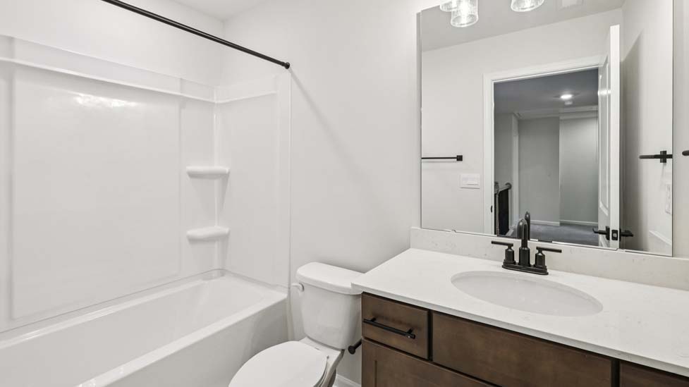 Bathroom with white cabinets and a shower/tub combination