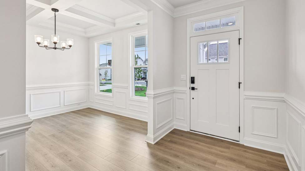 Welcoming foyer with staircase view and wood floors