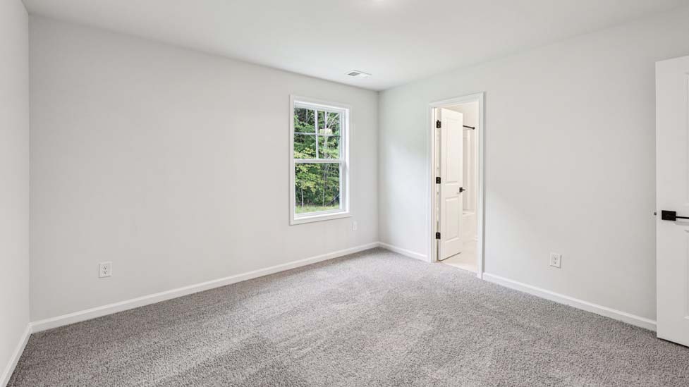 Carpeted bedroom with small window