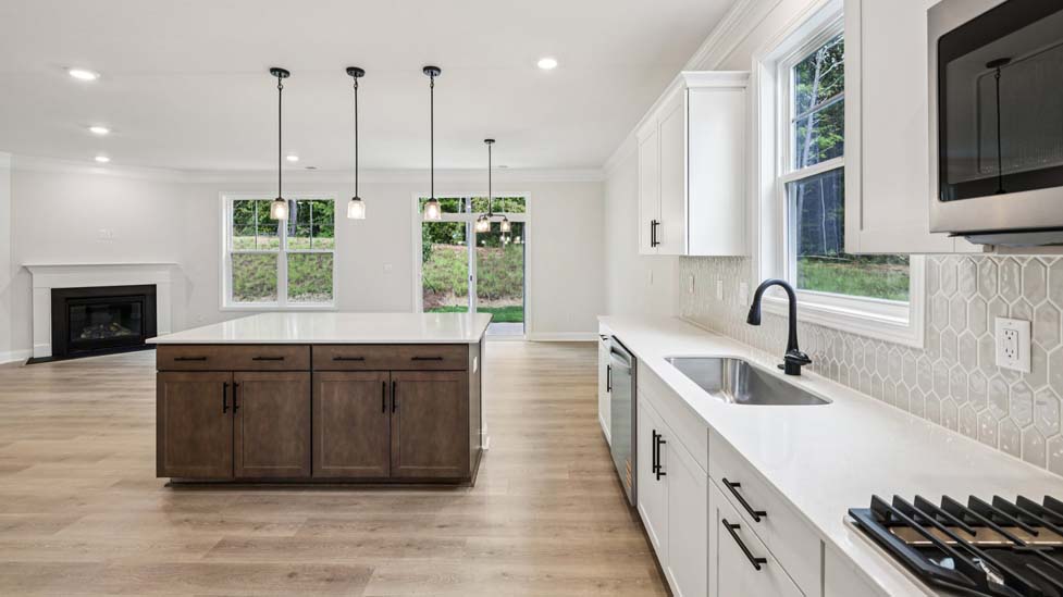 Kitchen and island with white cabinets, breakfast area at island bar, and stainless steel appliances