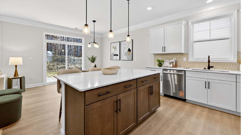 Kitchen and island with white cabinets, breakfast area at island bar, and stainless steel appliances