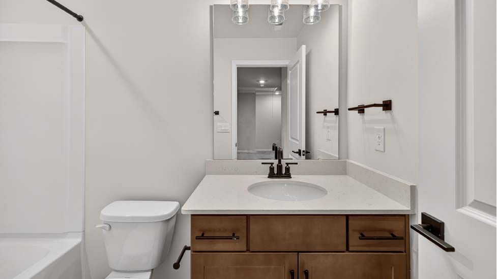 Bathroom with white cabinets and a shower/tub combination