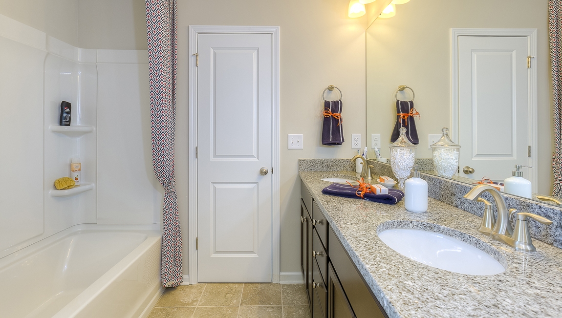 Bathroom with brown cabinets and bathtub