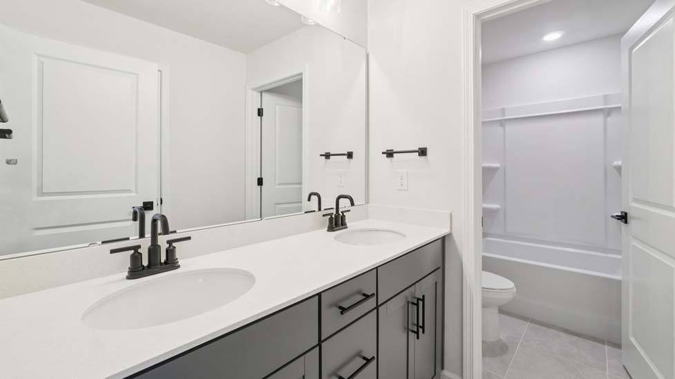 Bathroom with double sink vanity and shower tub combo