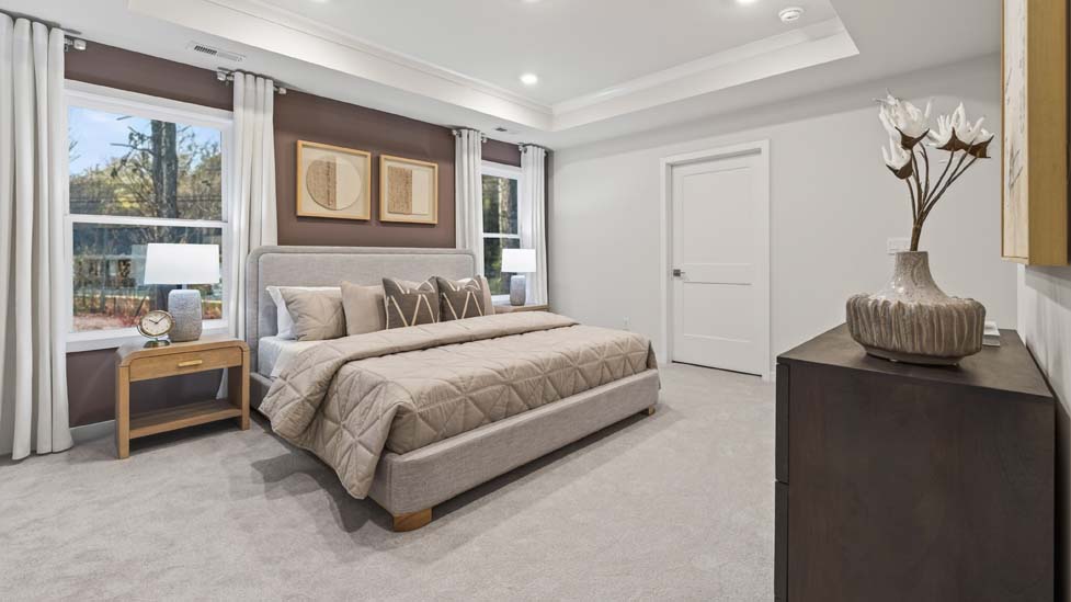 Primary carpeted bedroom with large windows
