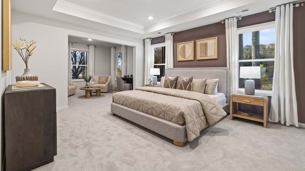 Primary carpeted bedroom with large windows