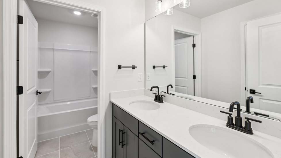 Bathroom with double sink vanity and shower tub combo
