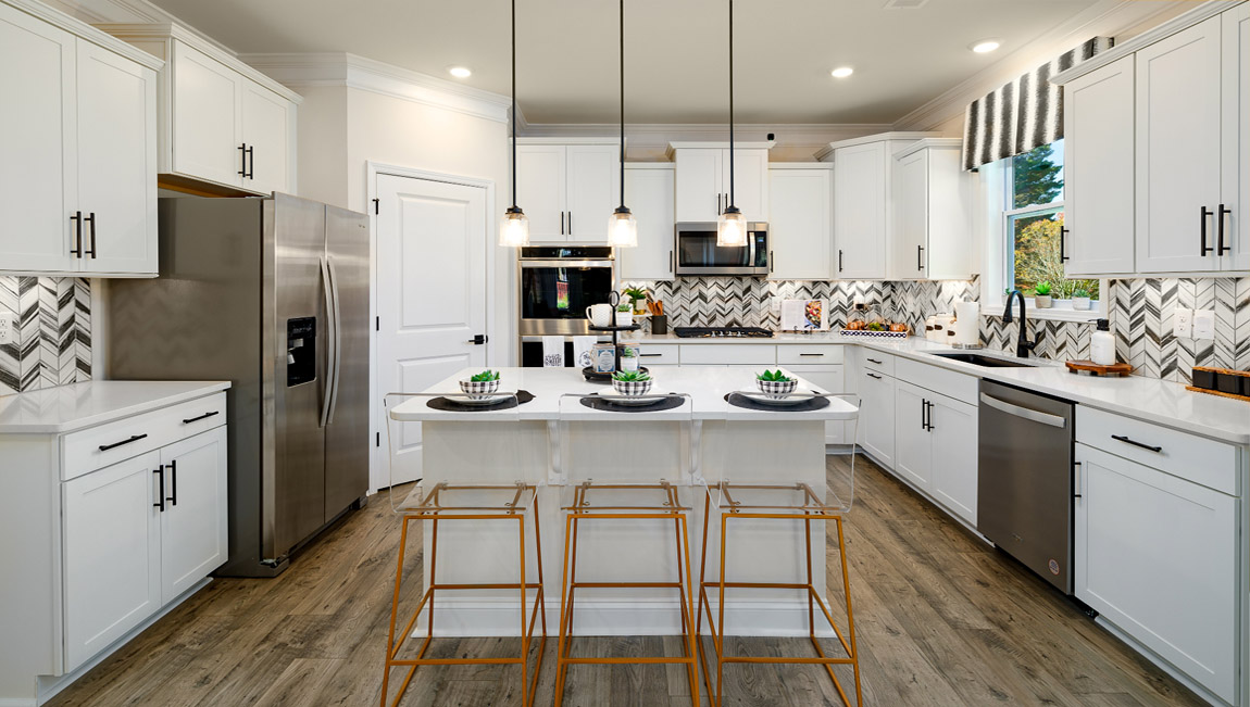 Kitchen and island with wood floors, white cabinets, quartz counters, and stainless steel appliances