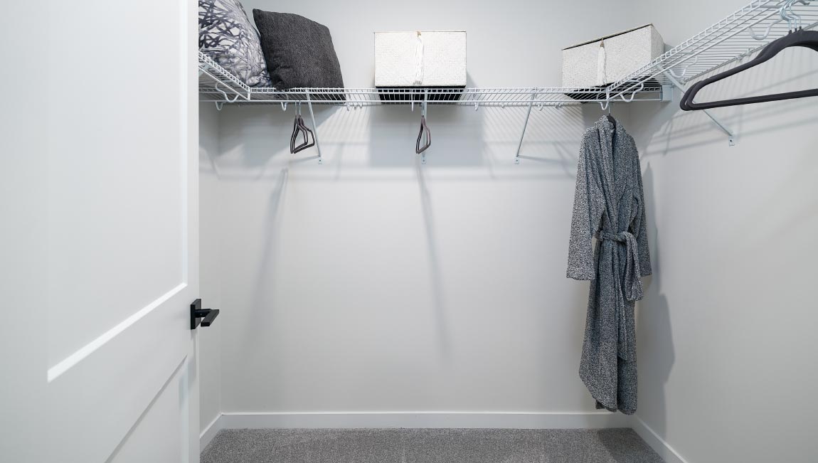 Carpeted walk in closet with built in hanger racks