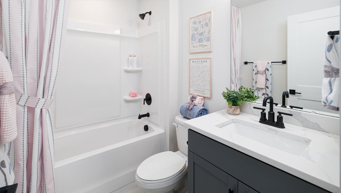 Bathroom with white counters, and cabinets and bathtub