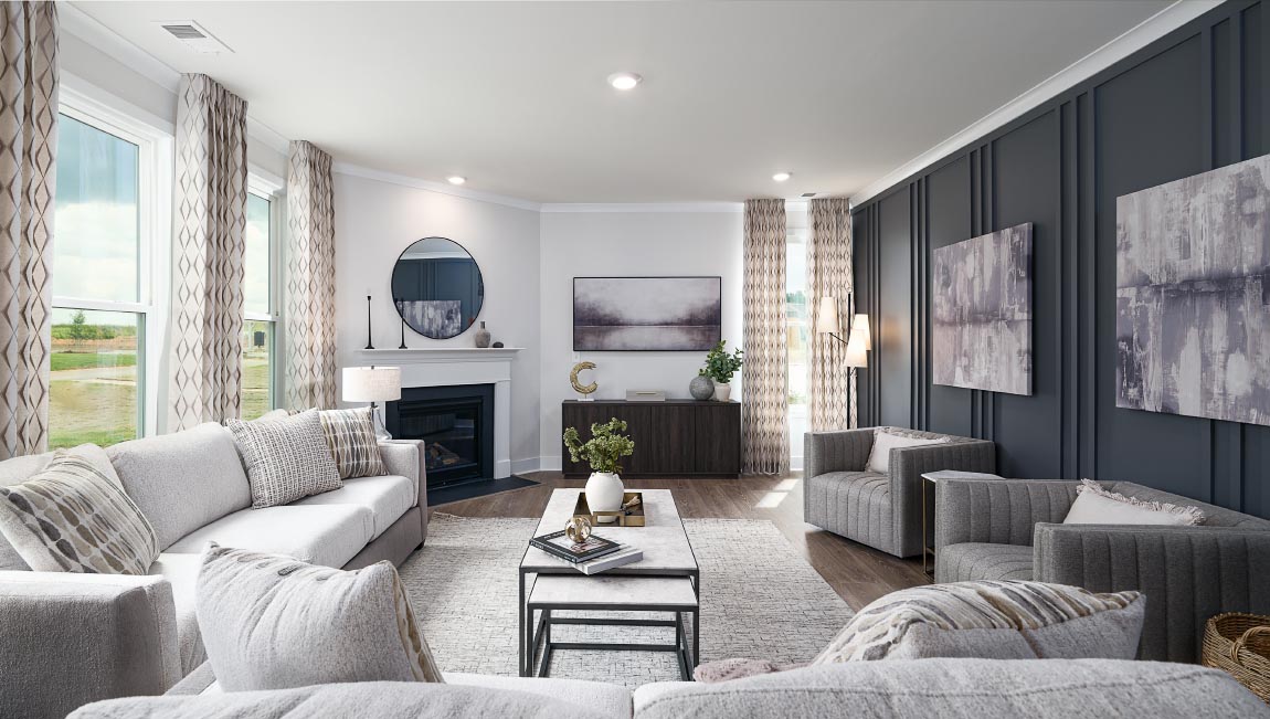 Open concept family room with wood floors, 3 large windows, and fireplace