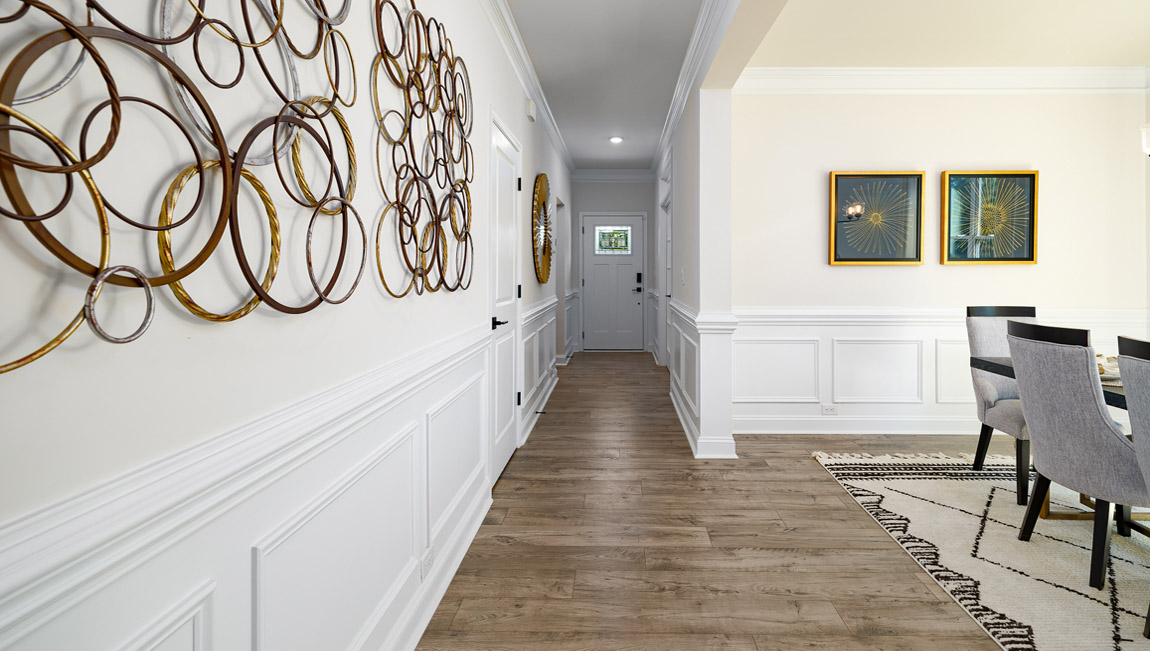 Welcoming foyer with wood floors, view of front door, and edge of dining room