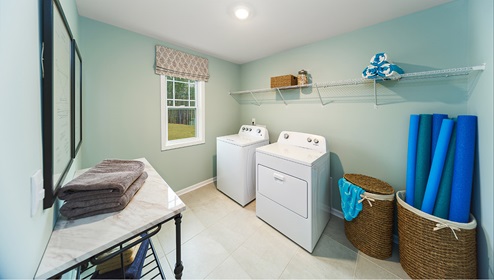 Laundry room with built in racks above machine space