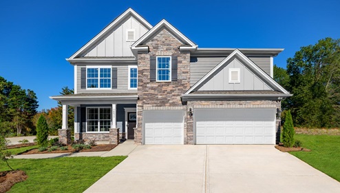 model front exterior with siding, stone, and three car garage