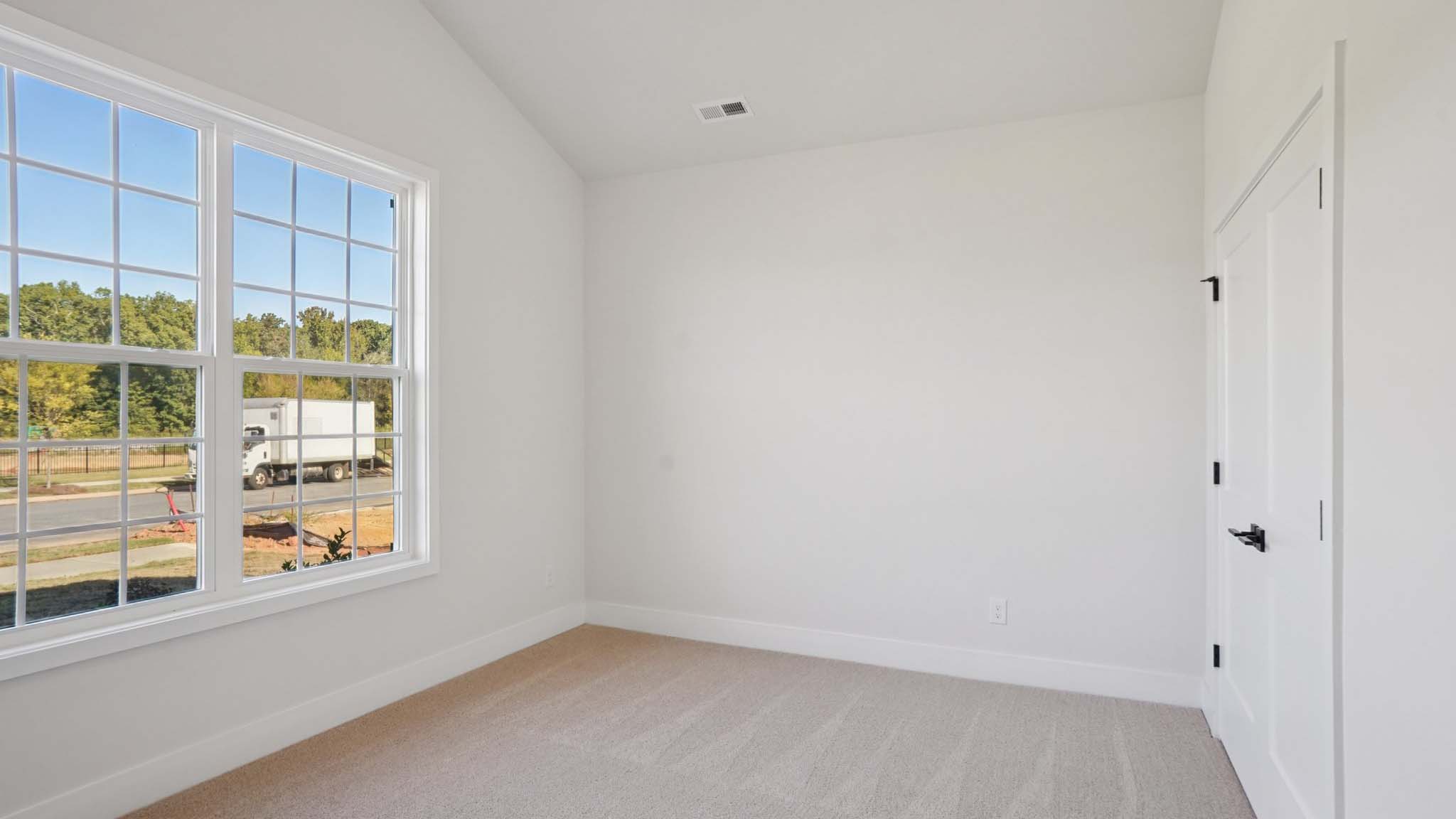 Carpeted bedroom with windows